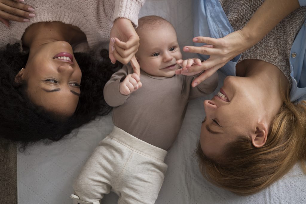 Dos madres con su bebe sonriendo